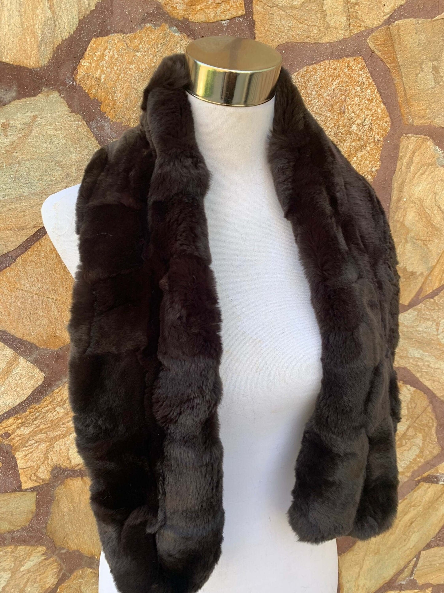 Rex Rabbit Fur Scarf Dark Brown - Tatifurs displayed on a mannequin against a textured stone background.