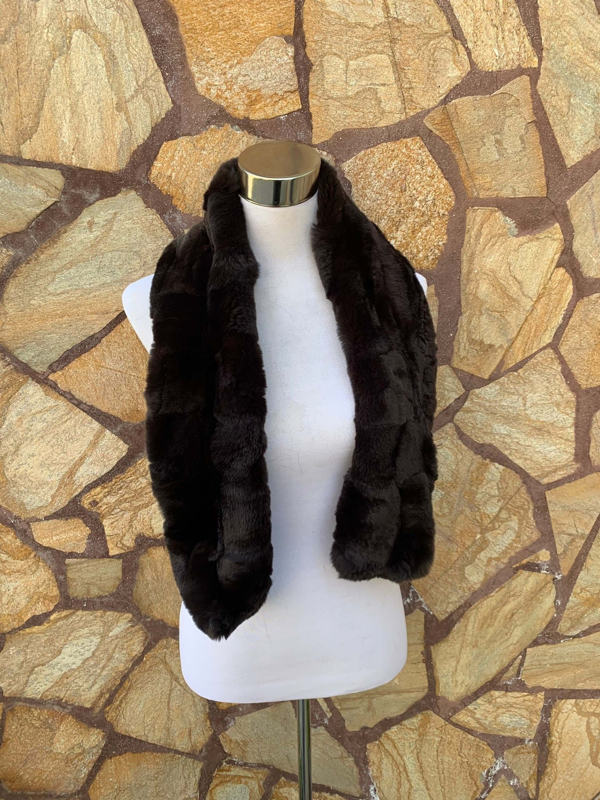 Rex Rabbit Fur Scarf Dark Brown - Tatifurs displayed on a mannequin against a stone wall.