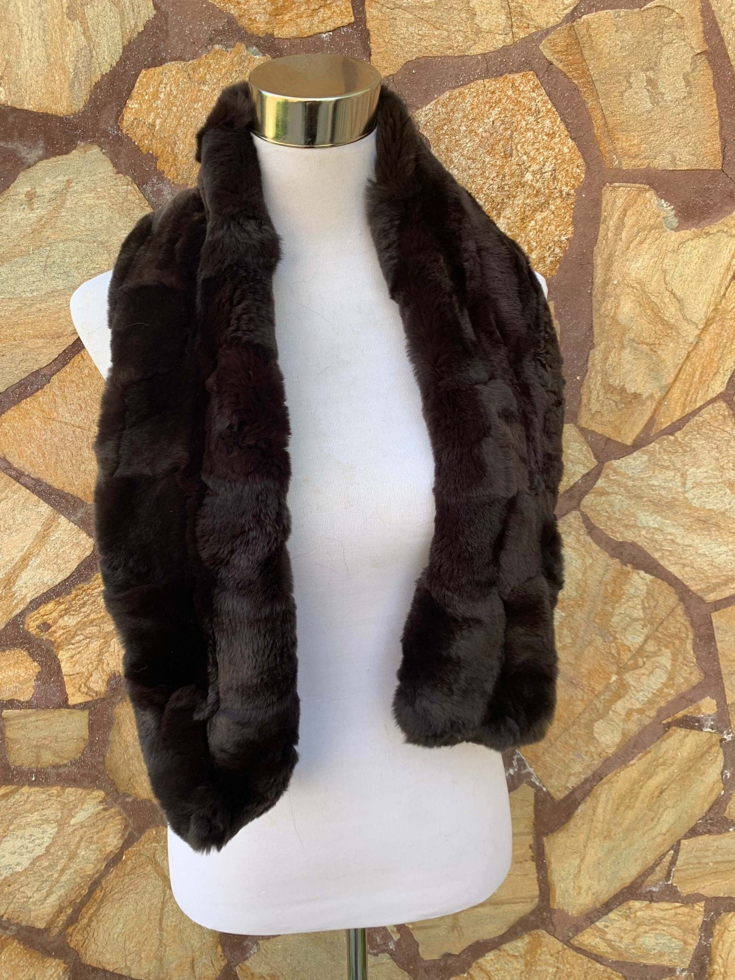 Rex Rabbit Fur Scarf Dark Brown - Tatifurs displayed on a mannequin against a stone background.